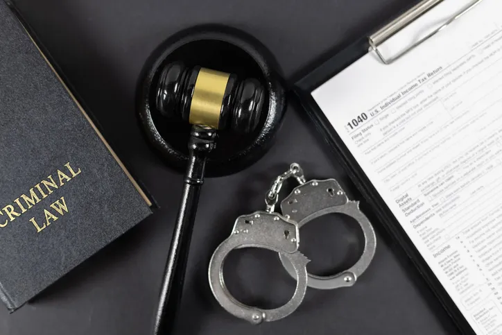 hand cuffs and a gavel on a black table